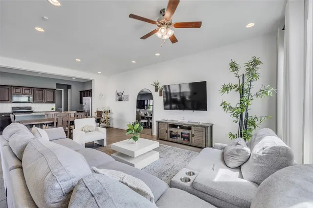 a living room with furniture a flat screen tv and a potted plant