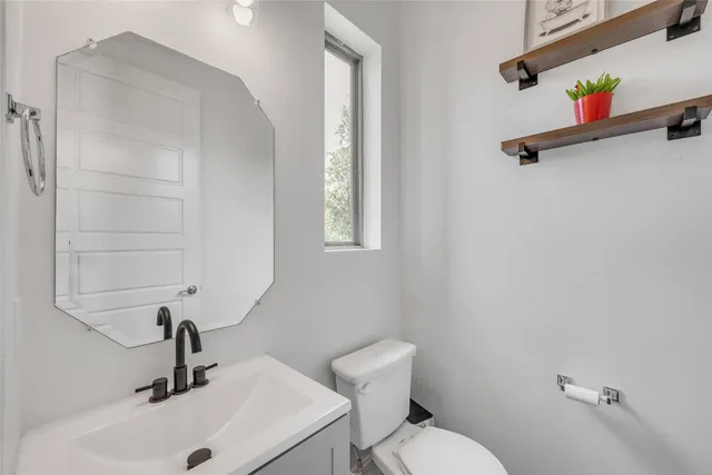 a bathroom with a sink a toilet and a mirror