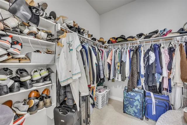 a view of walk in closet with clothes and shoes
