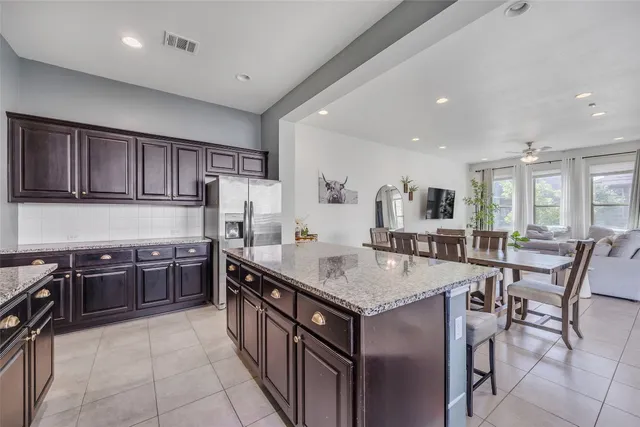 a kitchen with stainless steel appliances granite countertop table chairs sink and stove