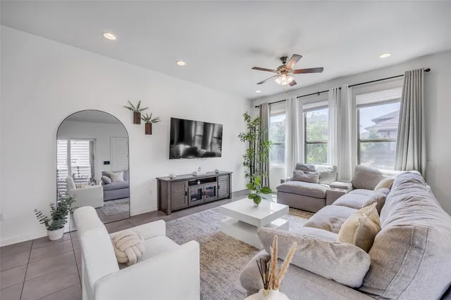 a living room with furniture ceiling fan and a flat screen tv