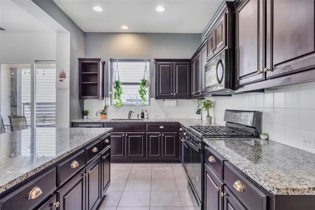 a kitchen with stainless steel appliances granite countertop a sink stove and cabinets
