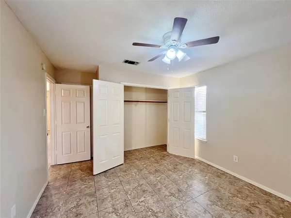 a view of an empty room with a ceiling fan