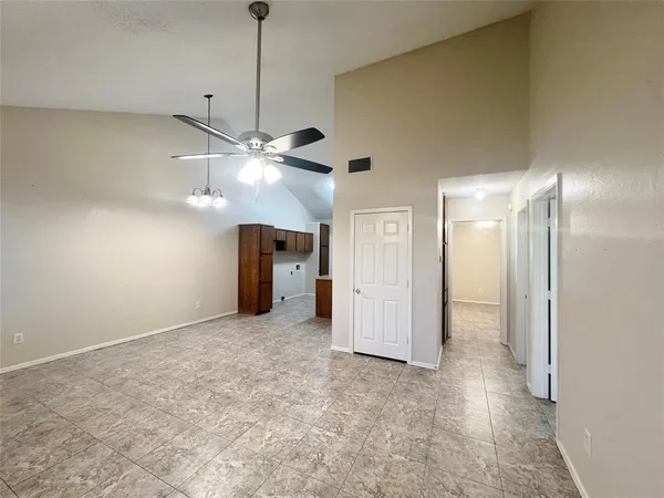 a view of a room with a ceiling fan and closet area