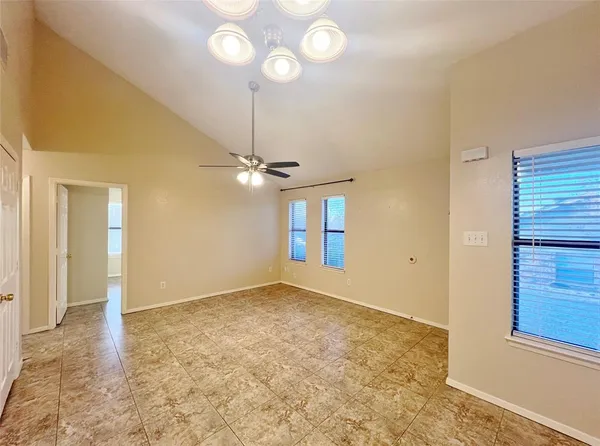 en view of an empty room and chandelier fan