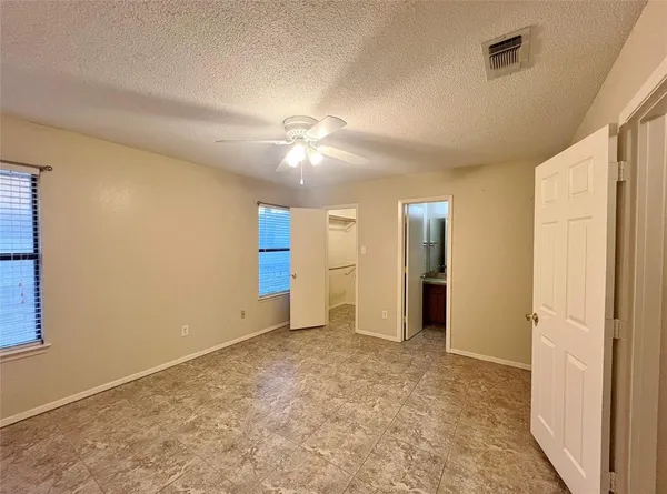 en empty room with an entryway and fan