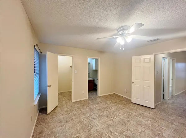 an empty room with closet and a ceiling fan