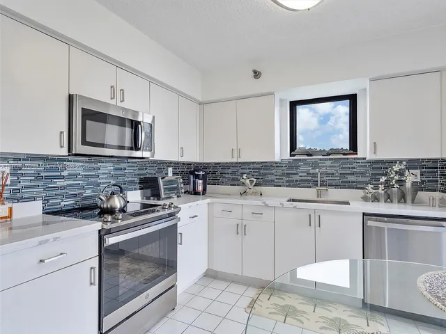 a kitchen with granite countertop white cabinets white stainless steel appliances with a sink and dishwasher
