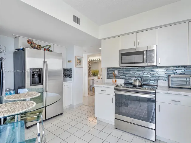 a kitchen with stainless steel appliances granite countertop a refrigerator stove microwave and sink