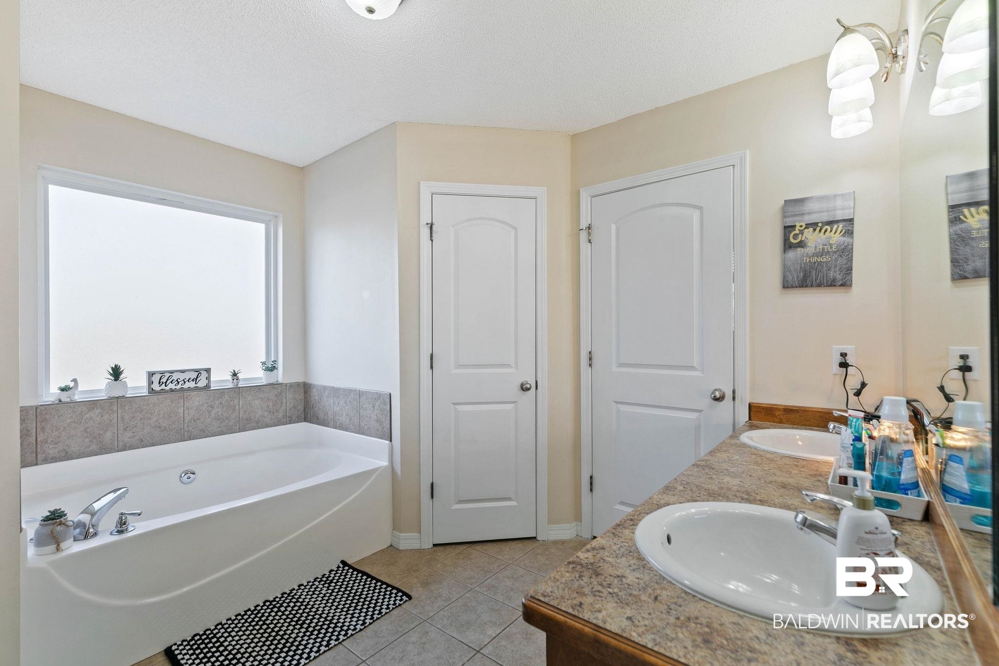 55750 Lottie Road Perdido, AL 36562 - Photo 54 of 84 Bathroom with a garden tub, double vanity, and light tile patterned floors