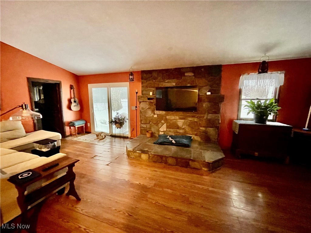 4298 South Ridge Road Perry, OH 44081 - Photo 12 of 32 Family room with a hearth, hardwood floors, sliding glass door to fenced in patio