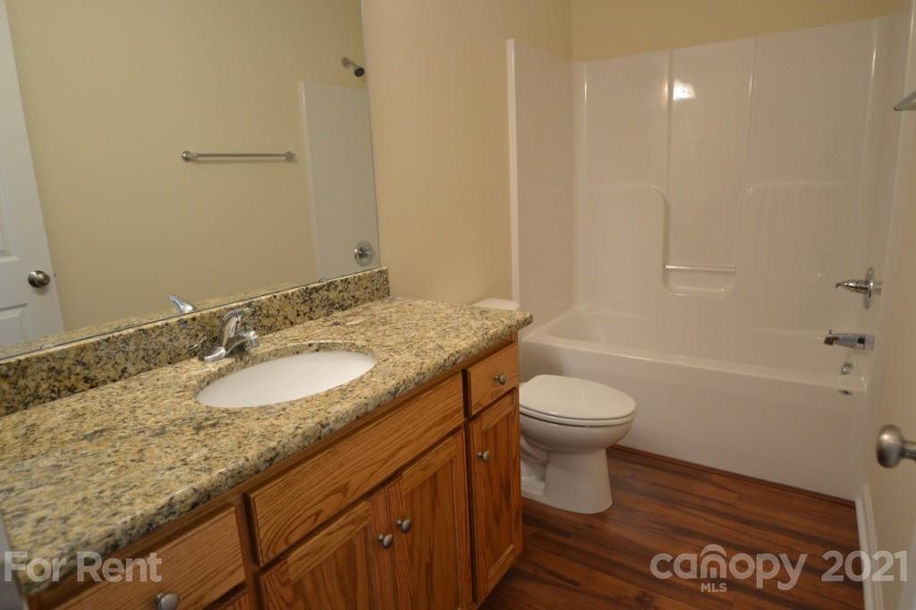 3801 Lee Moore Road Maiden, NC 28650 - Photo 5 of 14 a bathroom with a granite countertop sink toilet and shower