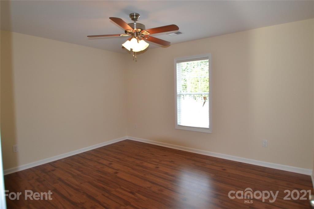 3801 Lee Moore Road Maiden, NC 28650 - Photo 7 of 14 an empty room with wooden floor and windows