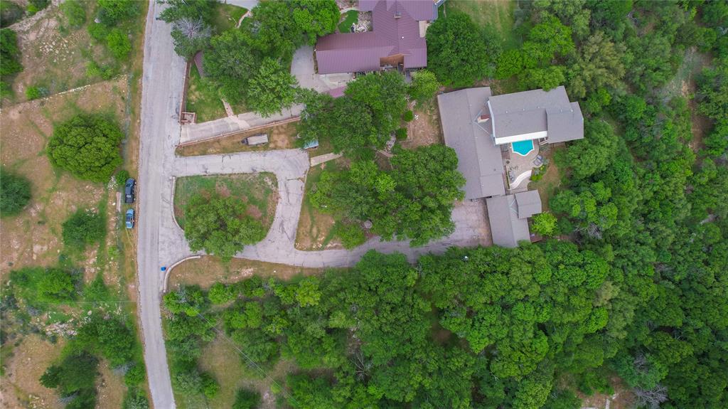an aerial view of a house with a yard and greenery