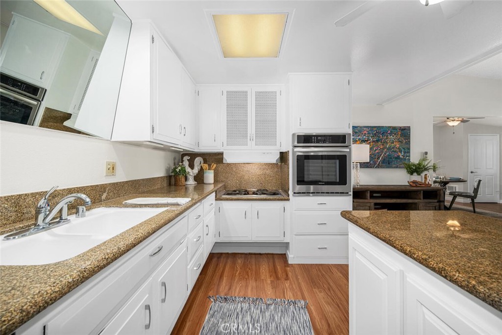 1240 Oakmont Road, Unit 52I Seal Beach, CA 90740 - Photo 26 of 33 a kitchen with granite countertop a sink stove and cabinets