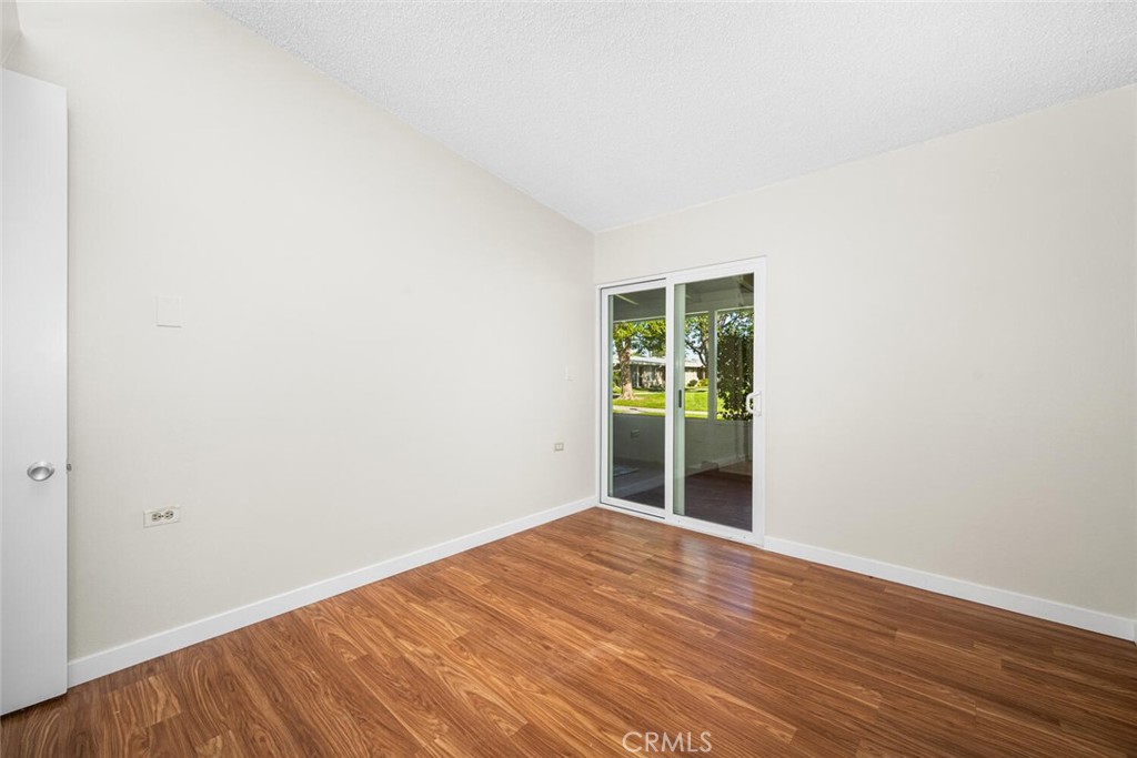 1240 Oakmont Road, Unit 52I Seal Beach, CA 90740 - Photo 31 of 33 a view of an empty room with wooden floor and a window