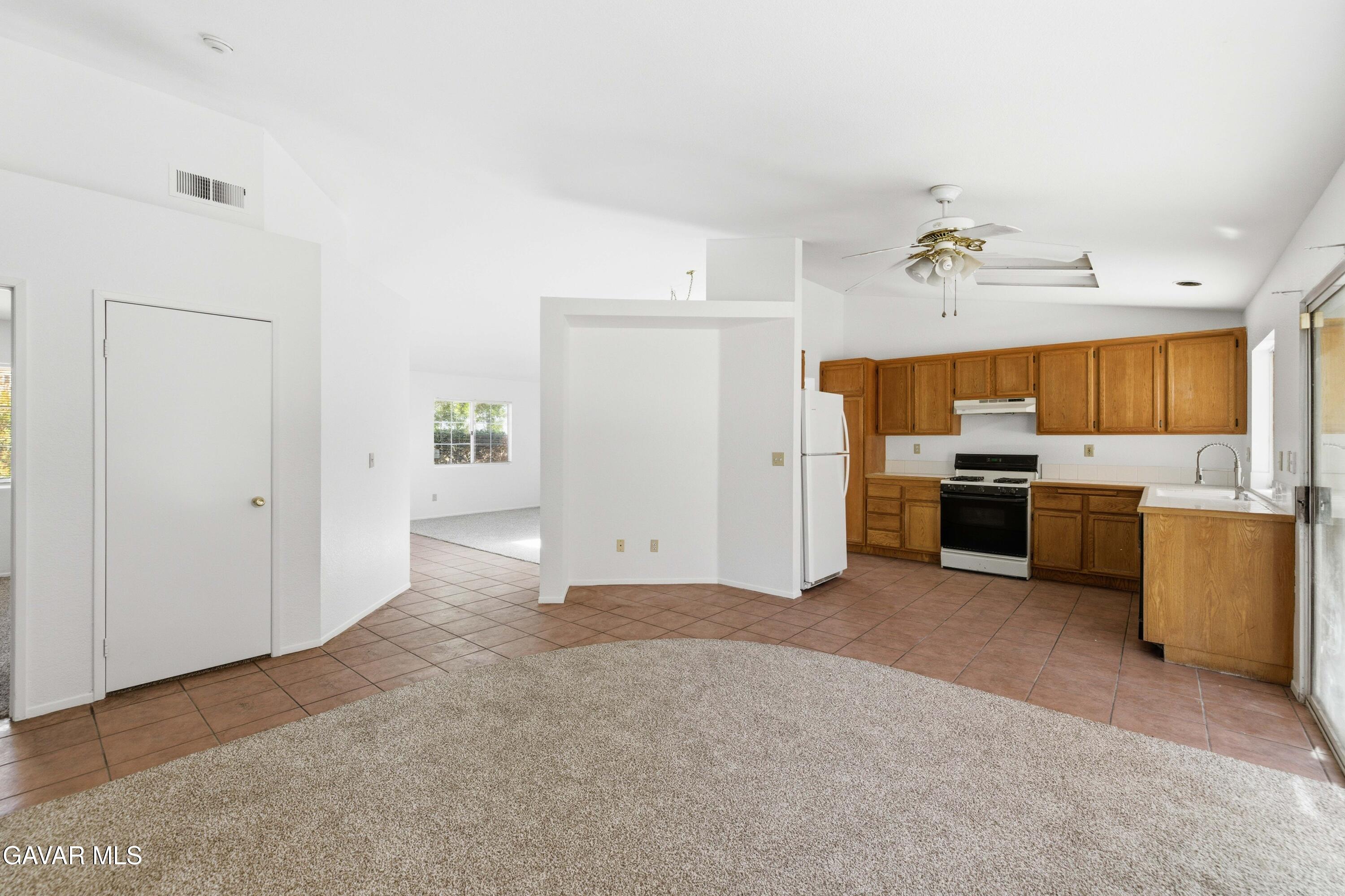 3254 Quarry Road Palmdale, CA 93550 - Photo 12 of 30 a view of a kitchen with wooden cabinet and a stove top oven