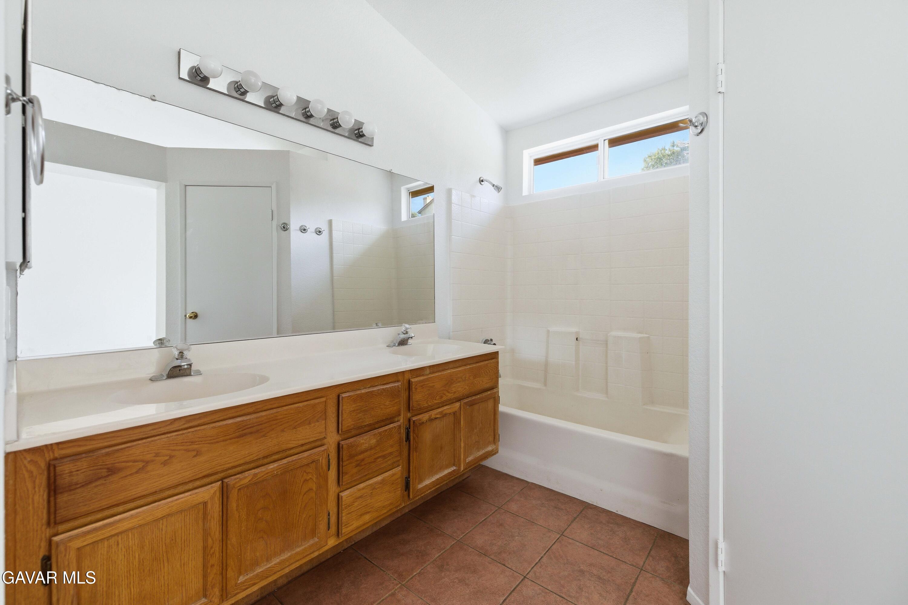 3254 Quarry Road Palmdale, CA 93550 - Photo 22 of 30 a spacious bathroom with a granite countertop sink mirror and a