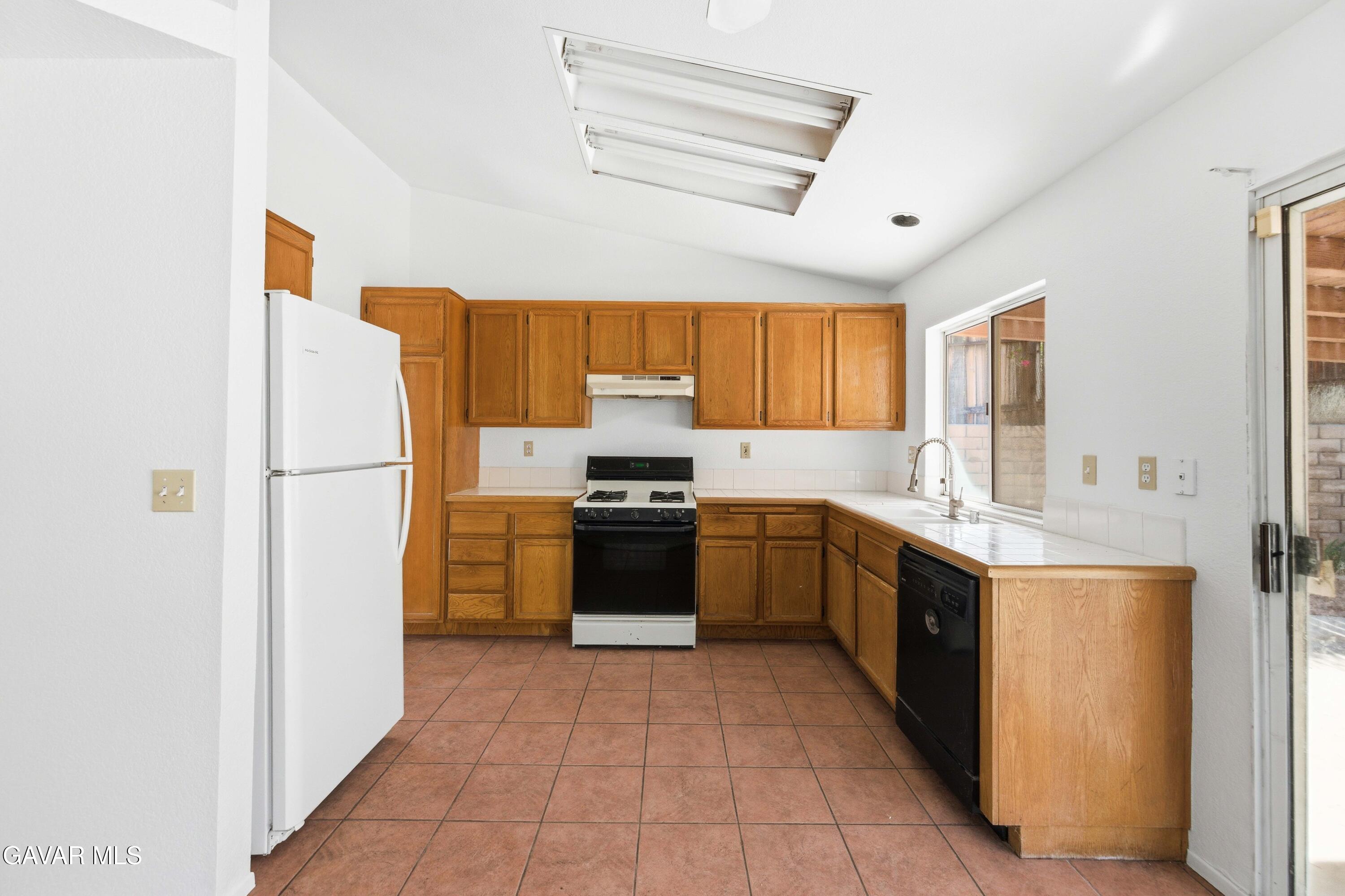 3254 Quarry Road Palmdale, CA 93550 - Photo 7 of 30 a kitchen with stainless steel appliances granite countertop a refrigerator sink and stove
