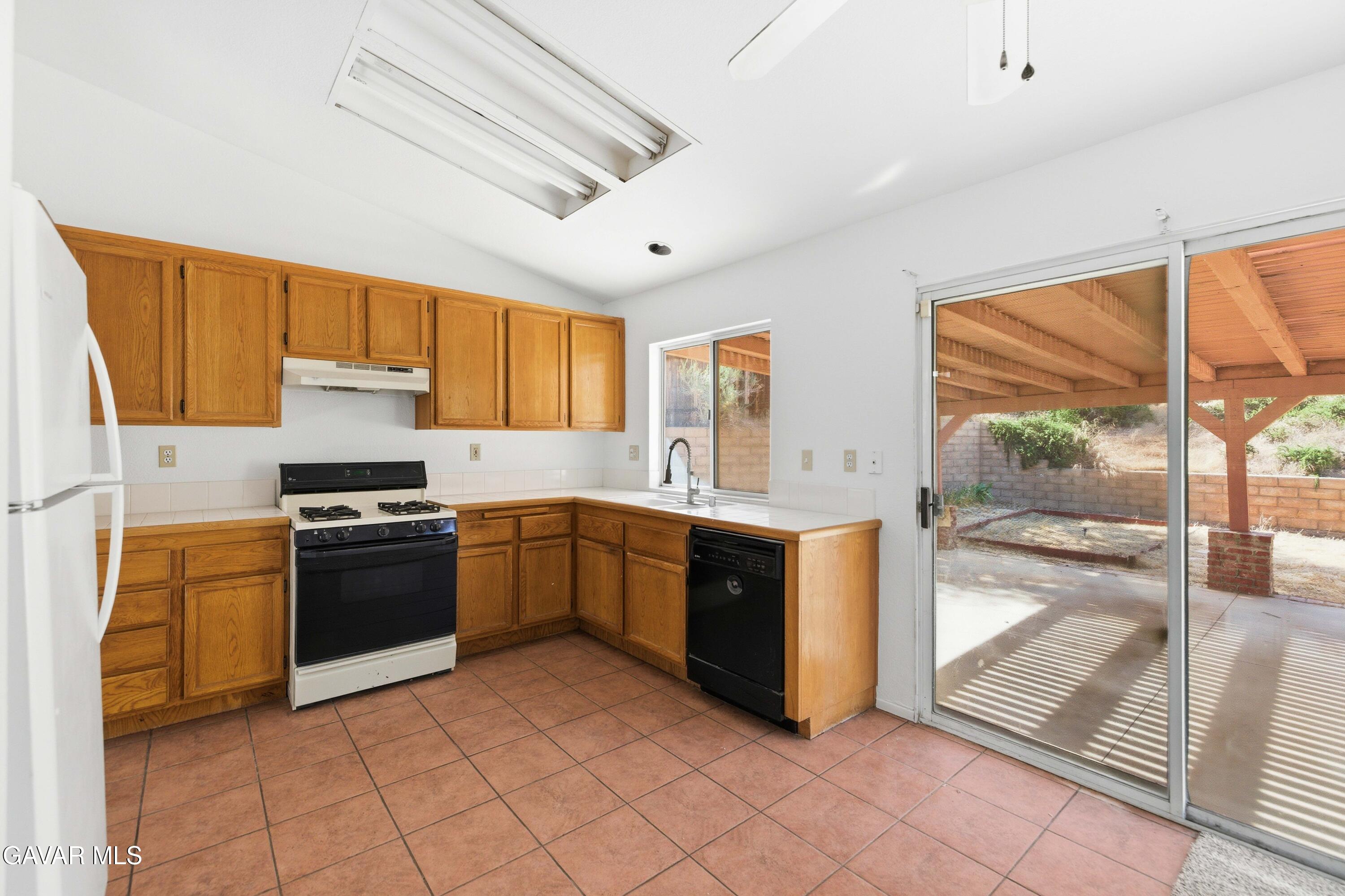 3254 Quarry Road Palmdale, CA 93550 - Photo 8 of 30 a kitchen with stainless steel appliances granite countertop a stove a sink and a refrigerator
