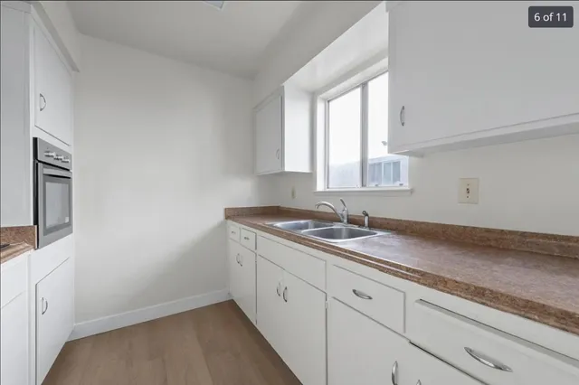 a bathroom with a granite countertop sink and a window