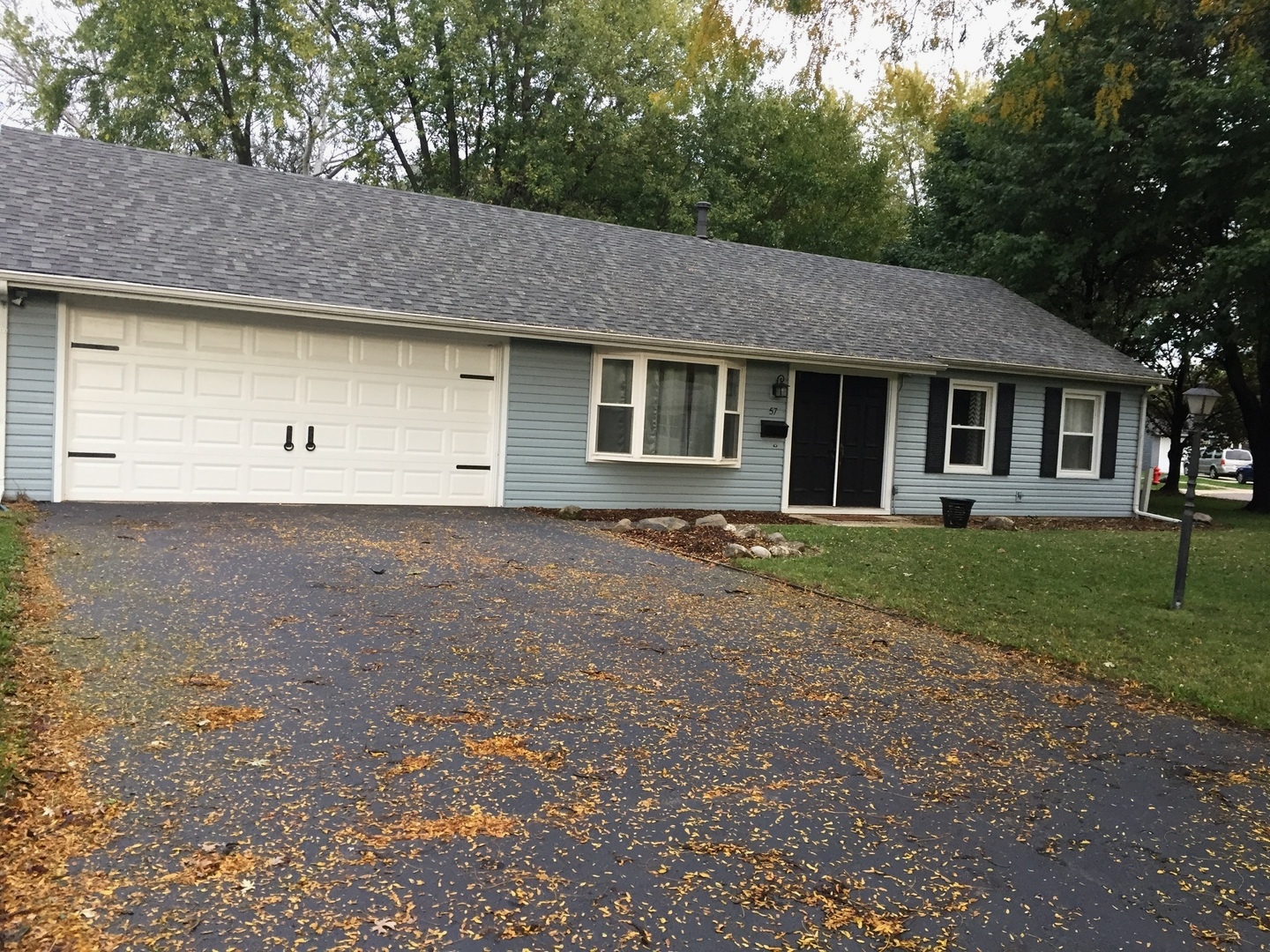 a front view of a house with a yard and trees