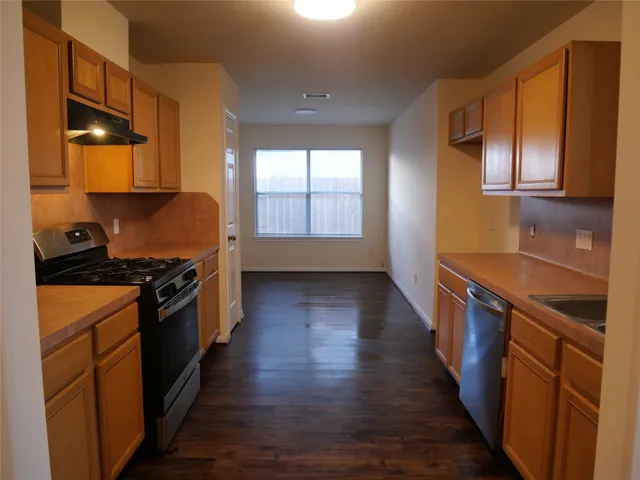 a kitchen with stainless steel appliances granite countertop a stove a sink and a refrigerator