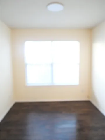 a view of a small space with wooden floor and a window