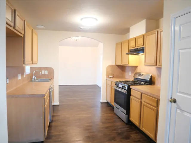 a kitchen with granite countertop a sink and a stove top oven