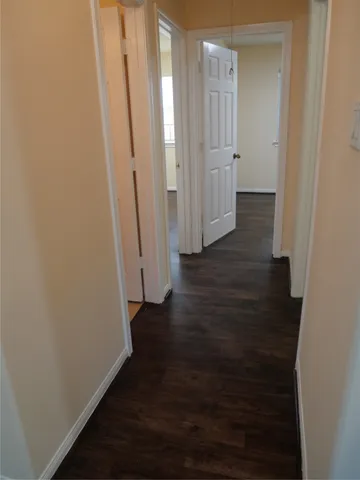 a view of a hallway with wooden floor