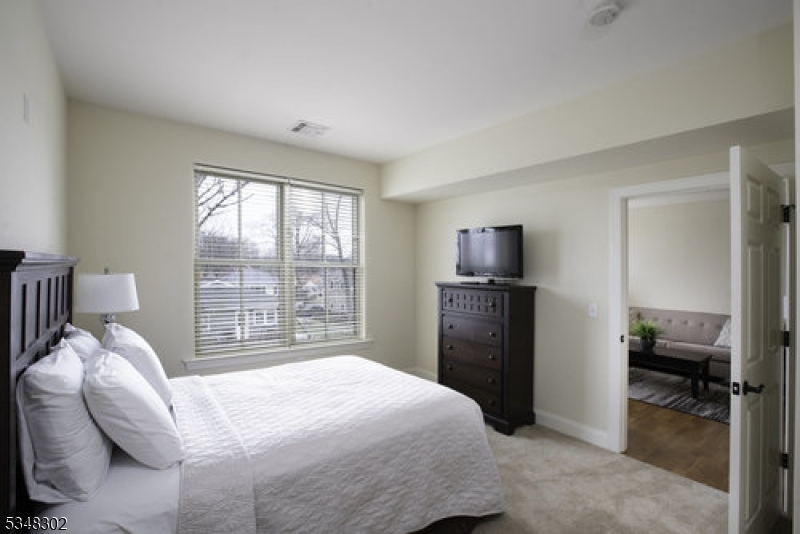 545 Morris Avenue, Unit 213 Summit, NJ 07901 - Photo 6 of 8 a bedroom with a bed and a television