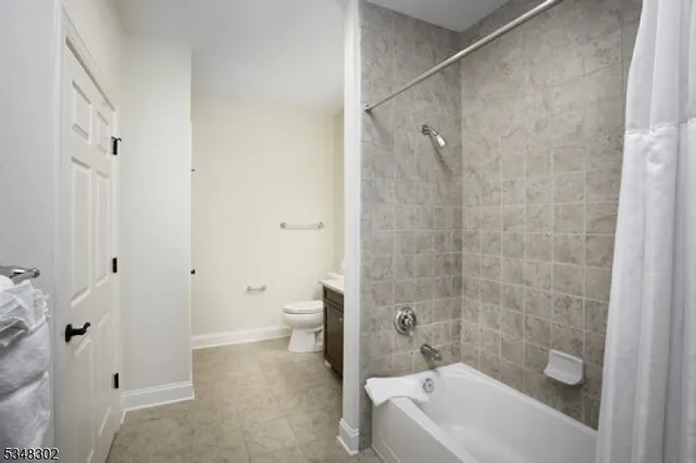 a bathroom with a granite countertop bathtub shower and toilet