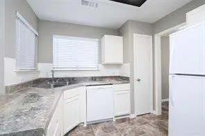 a kitchen with granite countertop a sink and a refrigerator