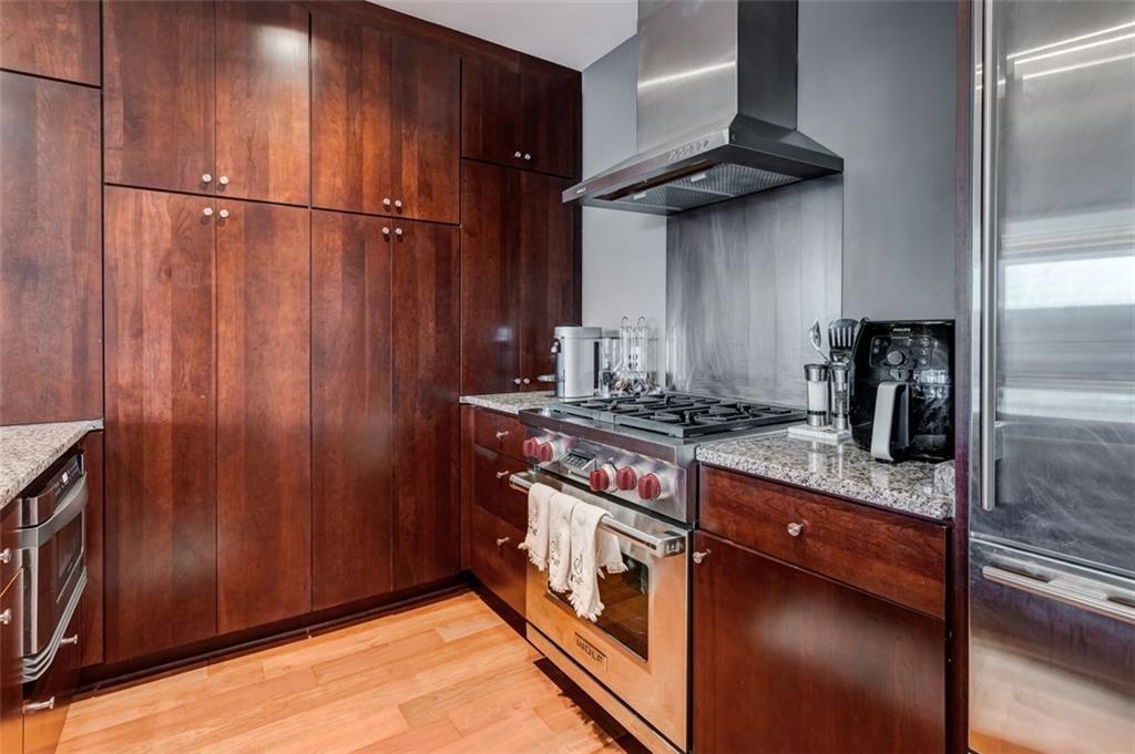 3325 Piedmont Road Northeast, Unit 1509 Atlanta, GA 30305 - Photo 12 of 29 a kitchen with stainless steel appliances granite countertop a refrigerator a sink and wooden cabinets