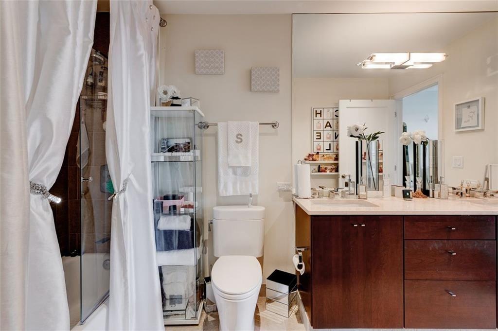 3325 Piedmont Road Northeast, Unit 1509 Atlanta, GA 30305 - Photo 16 of 29 a bathroom with a sink vanity mirror and toilet