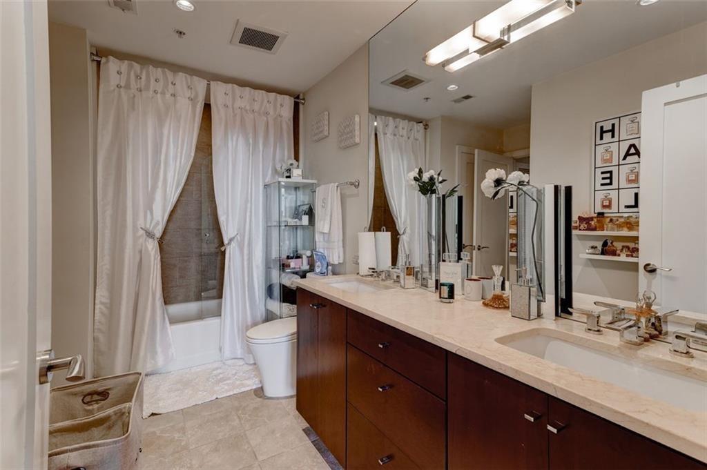 3325 Piedmont Road Northeast, Unit 1509 Atlanta, GA 30305 - Photo 17 of 29 a bathroom with a double vanity sink a mirror and a shower