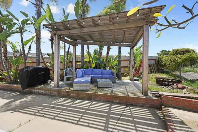 a view of a patio with table and chairs potted plants and floor to ceiling window