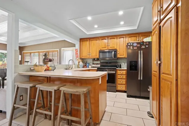 a kitchen with a stove a refrigerator and a dining table