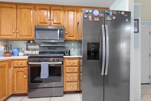 a kitchen with stainless steel appliances granite countertop a refrigerator stove and cabinets