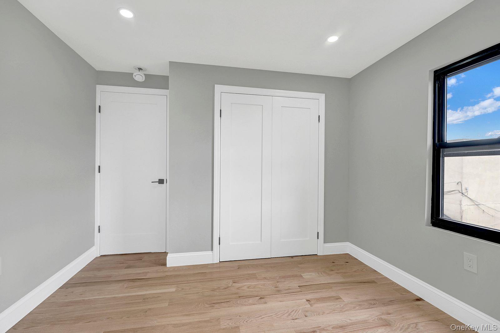 217-14 133rd Road Queens, NY 11413 - Photo 22 of 32 a view of an empty room with wooden floor and a window