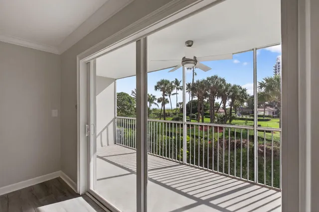 a view of a balcony with a floor to ceiling window and wooden fence