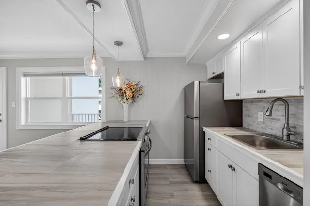 a kitchen with a refrigerator sink and cabinets