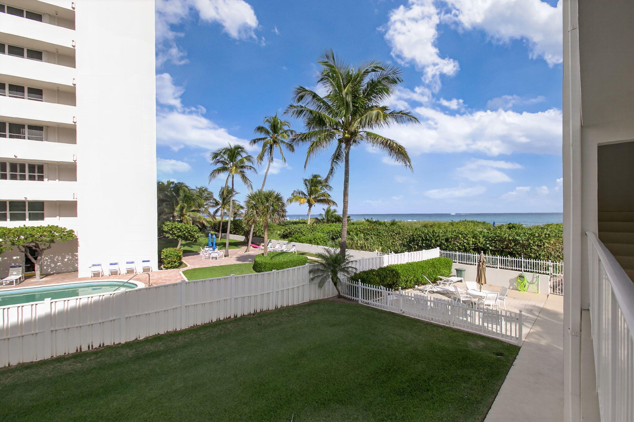 3600 North Ocean Drive, Unit 223 Singer Island, FL 33404 - Photo 39 of 47 a view of a house with a yard and table and chairs under an umbrella