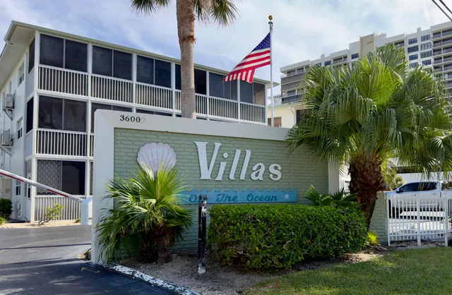 a view of sign board with potted plants