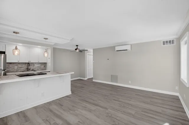 a view of a kitchen with a sink and wooden floor