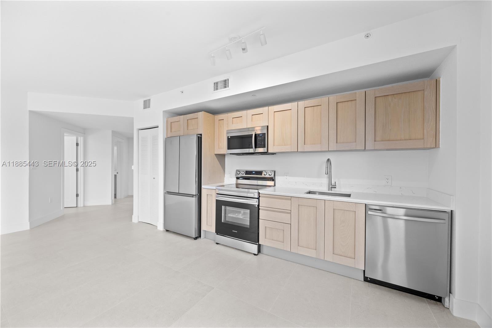 21850 Old Dixie Highway, Unit 1 Miami, FL 33170 - Photo 9 of 13 a kitchen with white cabinets and stainless steel appliances