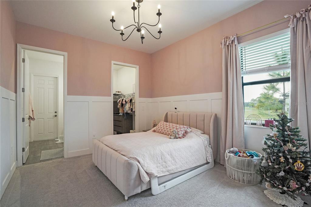 15906 Tradewind Terrace Lakewood Ranch, FL 34211 - Photo 26 of 67 a bedroom with a large bed and a chandelier