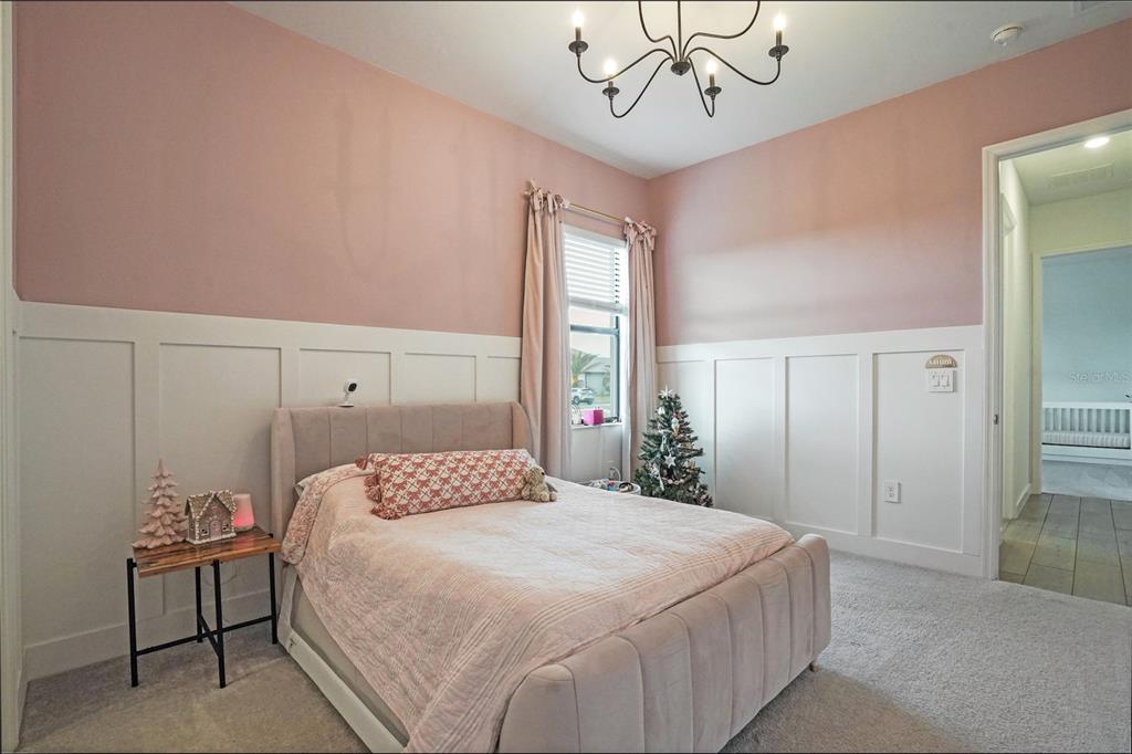 15906 Tradewind Terrace Lakewood Ranch, FL 34211 - Photo 27 of 67 a bedroom with a large bed and a chandelier