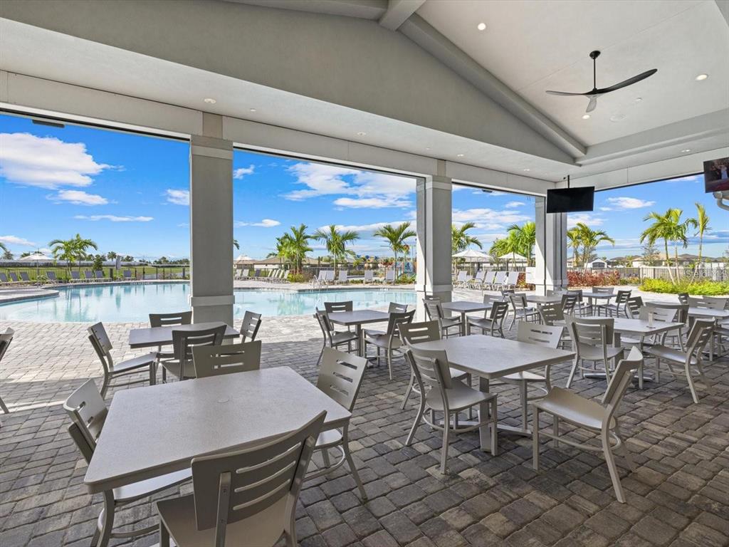 15906 Tradewind Terrace Lakewood Ranch, FL 34211 - Photo 42 of 67 a view of a dining room with furniture large windows and wooden floor