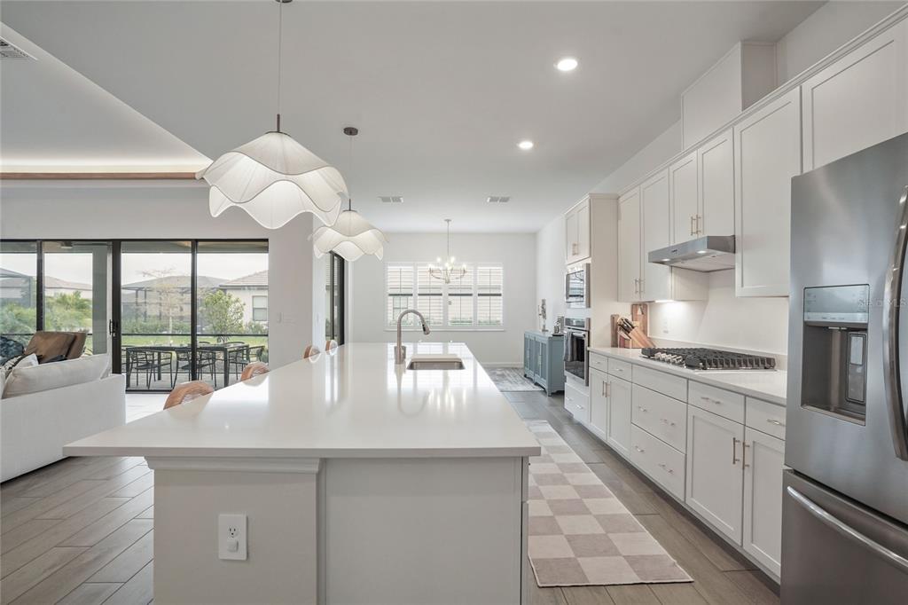 15906 Tradewind Terrace Lakewood Ranch, FL 34211 - Photo 10 of 67 a large kitchen with kitchen island granite countertop a large window and stainless steel appliances
